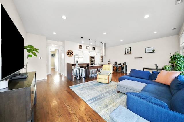 living room with baseboards, wood finished floors, and recessed lighting