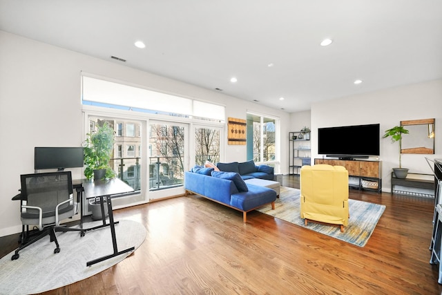 living room featuring baseboards, wood finished floors, visible vents, and recessed lighting