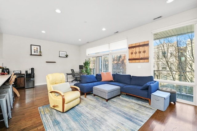 living room featuring baseboards, visible vents, dark wood-style flooring, and recessed lighting