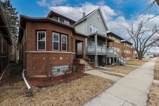 view of front of home with covered porch and brick siding