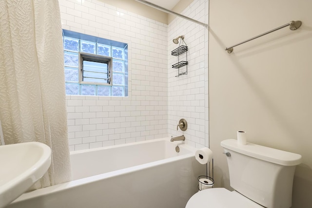 bathroom featuring shower / bath combo, a sink, and toilet