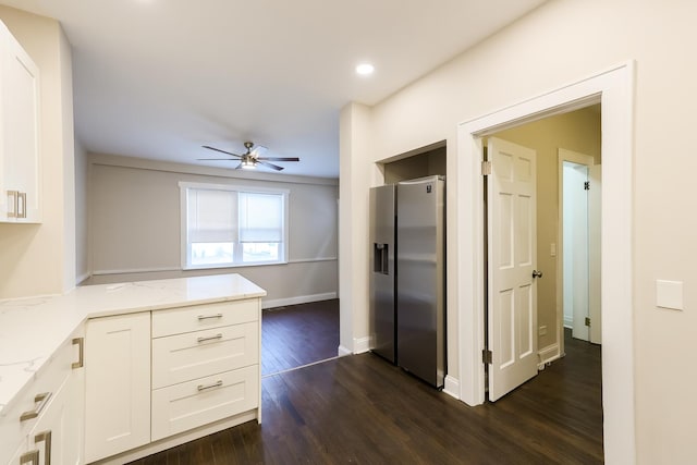 kitchen featuring dark wood finished floors, light stone counters, a peninsula, white cabinetry, and stainless steel refrigerator with ice dispenser