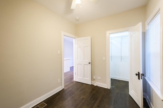 unfurnished bedroom with dark wood-style flooring, ceiling fan, and baseboards