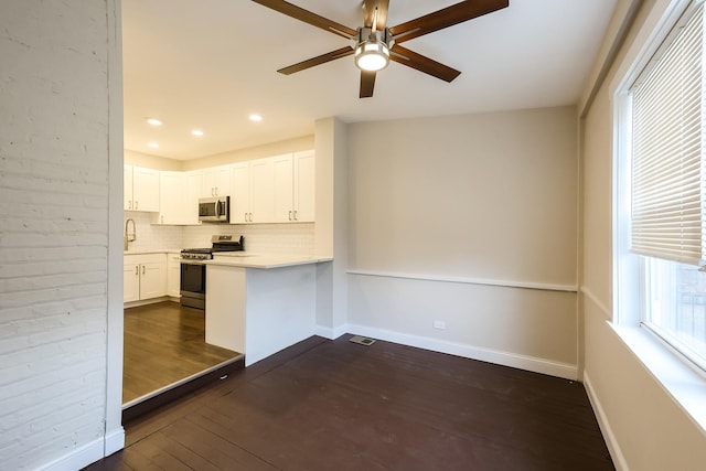 kitchen with stainless steel appliances, dark wood-style flooring, baseboards, light countertops, and tasteful backsplash