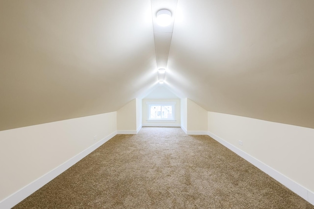 bonus room with baseboards, vaulted ceiling, and carpet flooring