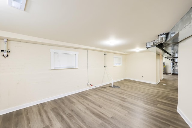 finished basement featuring visible vents, baseboards, and wood finished floors