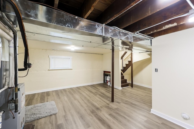 unfinished basement featuring stairs, baseboards, and wood finished floors