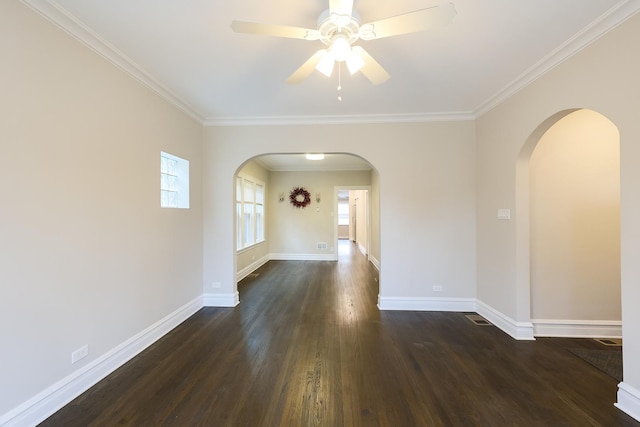 spare room featuring dark wood-style floors, arched walkways, ornamental molding, and baseboards