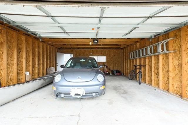 garage with wooden walls and a garage door opener