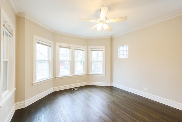 empty room with dark wood-style floors, crown molding, visible vents, ceiling fan, and baseboards