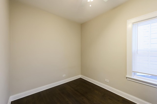 unfurnished room with dark wood-style floors, ceiling fan, and baseboards