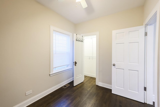 unfurnished bedroom with ceiling fan, dark wood-type flooring, visible vents, and baseboards