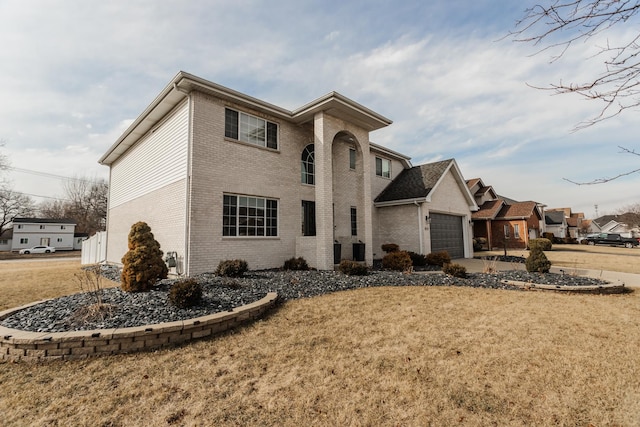 view of front of property with an attached garage, a front yard, and brick siding