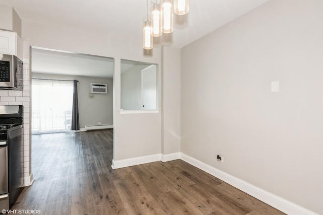 unfurnished dining area with dark wood-type flooring, a baseboard radiator, an AC wall unit, and baseboards