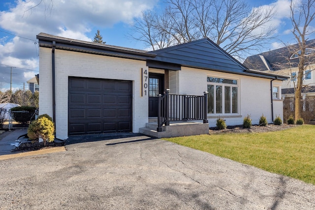 ranch-style house with a garage, driveway, brick siding, and a front yard