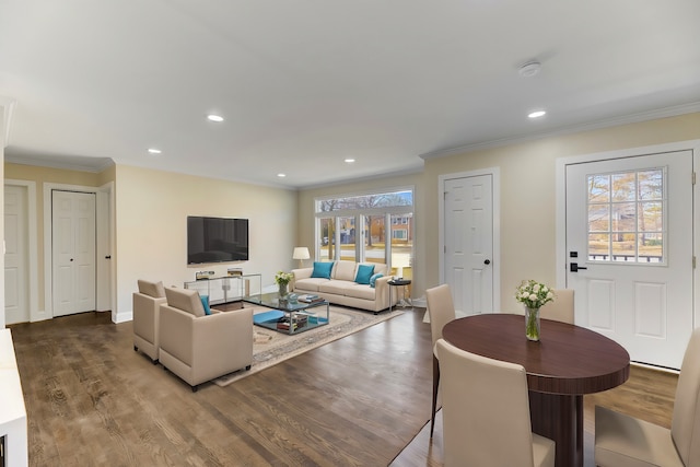 living area with baseboards, wood finished floors, and crown molding