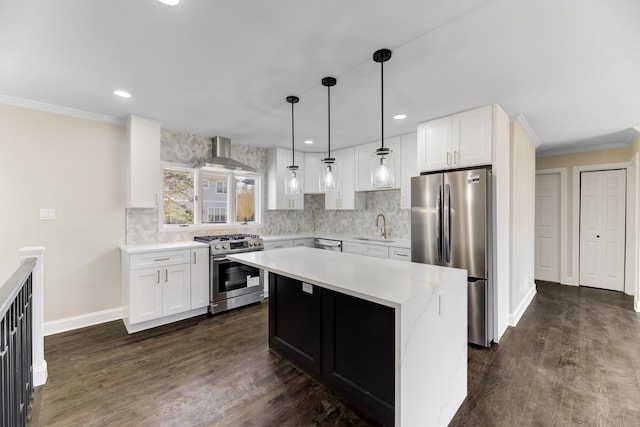 kitchen with light countertops, appliances with stainless steel finishes, ornamental molding, a sink, and wall chimney exhaust hood