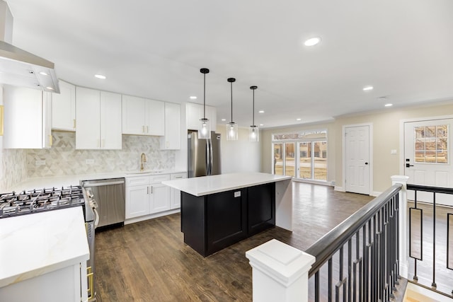 kitchen with stainless steel appliances, dark wood-style flooring, a sink, and a center island