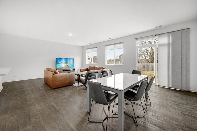 dining area with dark wood-style floors, visible vents, and baseboards