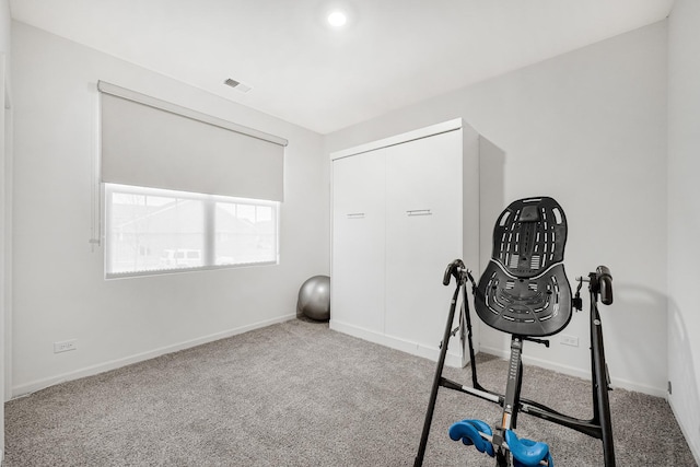 workout area featuring carpet floors, visible vents, and baseboards