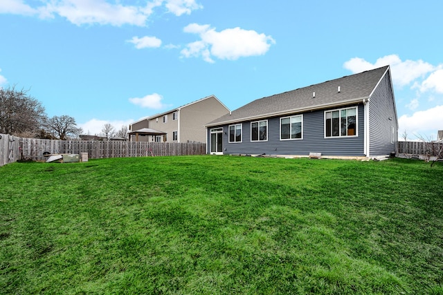 back of property featuring a fenced backyard and a yard