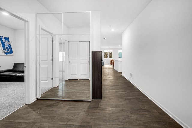 corridor featuring recessed lighting, dark wood-style flooring, visible vents, and baseboards