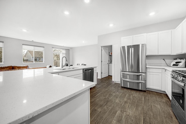 kitchen with white cabinetry, dark wood-style flooring, stainless steel appliances, and a sink