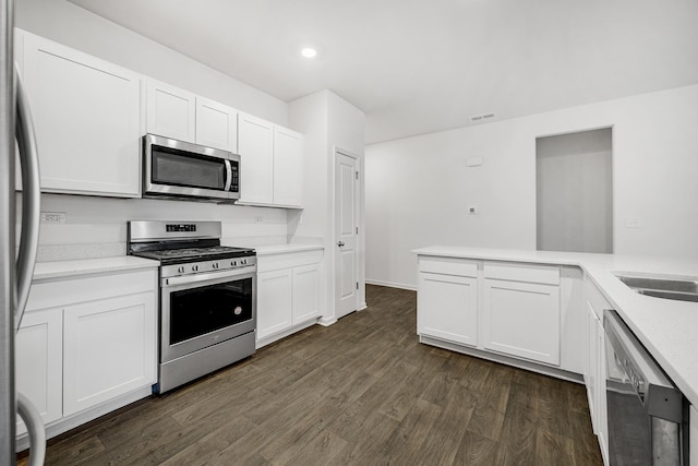 kitchen with recessed lighting, stainless steel appliances, visible vents, white cabinetry, and dark wood-style floors