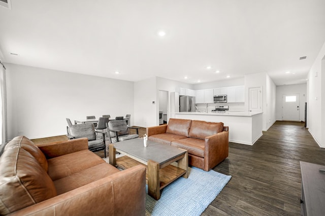 living area with baseboards, dark wood-type flooring, and recessed lighting