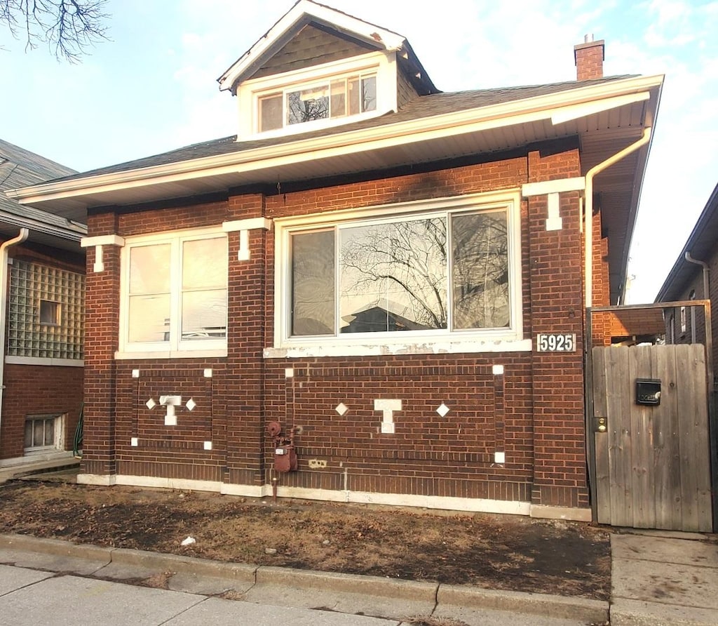 view of side of home featuring brick siding and a chimney