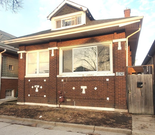 view of side of home featuring brick siding and a chimney