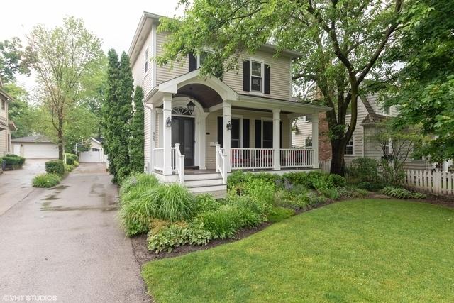 view of front of house featuring a garage, covered porch, and a front lawn