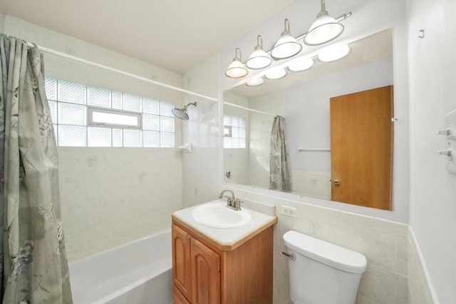 full bath featuring toilet, shower / bath combination with curtain, tile walls, and vanity