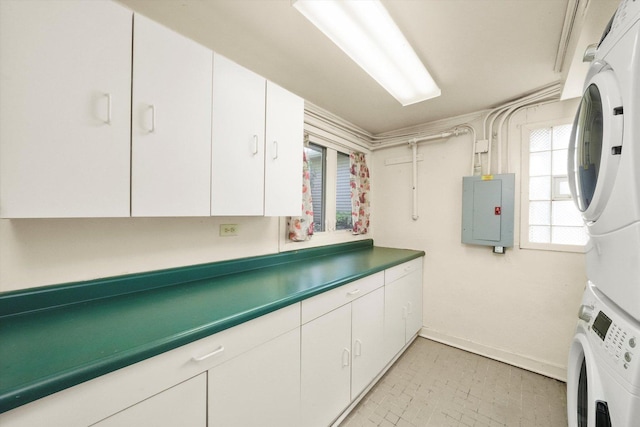 interior space with stacked washing maching and dryer, cabinet space, and electric panel