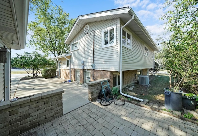 view of side of home featuring cooling unit and a patio