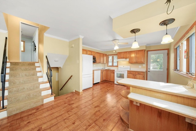 kitchen with crown molding, white appliances, light wood-style floors, and under cabinet range hood