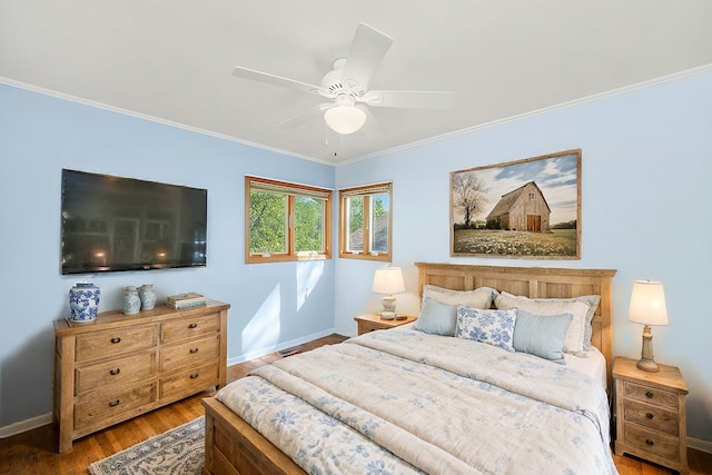 bedroom featuring ornamental molding, a ceiling fan, baseboards, and wood finished floors