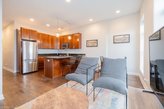 kitchen featuring stainless steel appliances, recessed lighting, dark wood finished floors, and brown cabinets