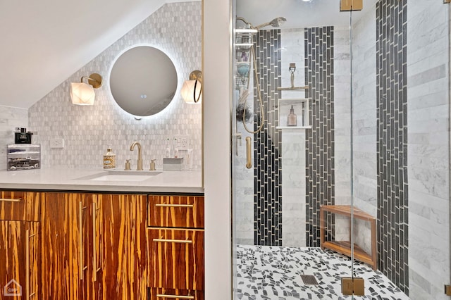 full bath featuring tasteful backsplash, a stall shower, vaulted ceiling, and vanity