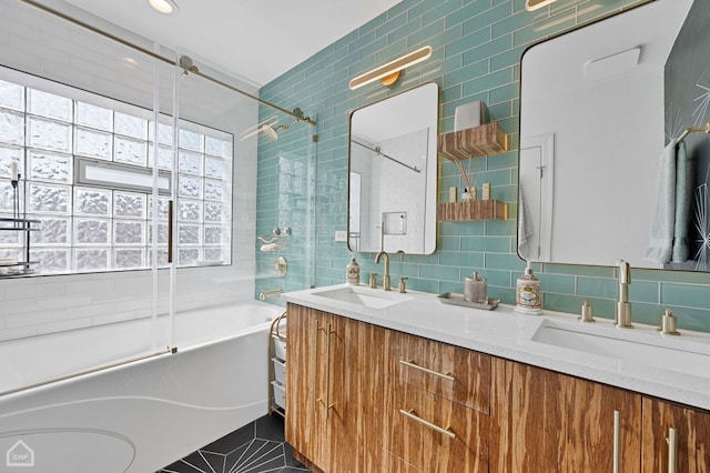 full bathroom featuring double vanity, tasteful backsplash, tile walls, and a sink