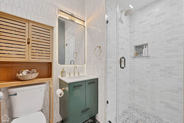 bathroom with vanity, a shower stall, and toilet