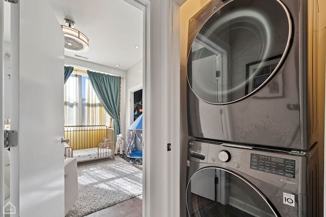 clothes washing area with laundry area and stacked washing maching and dryer