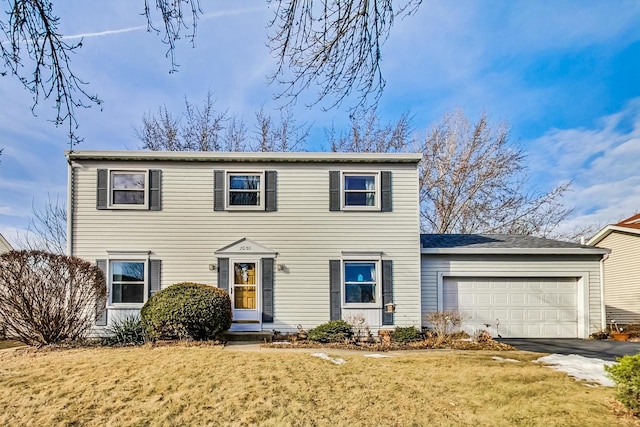 view of front of house featuring an attached garage, a front lawn, and aphalt driveway