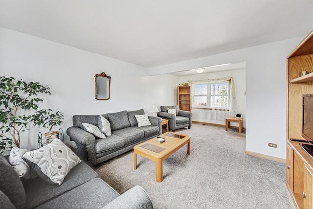 living area with light colored carpet and baseboards