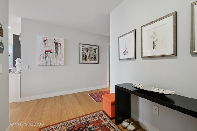 corridor featuring wood finished floors and baseboards