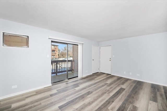 empty room featuring baseboards and wood finished floors