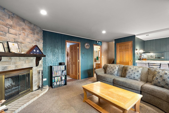 living room featuring carpet floors, recessed lighting, and a stone fireplace