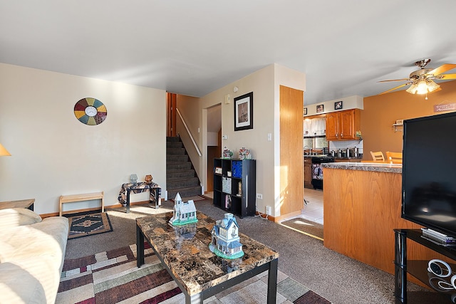 living room featuring light carpet, stairway, a ceiling fan, and baseboards