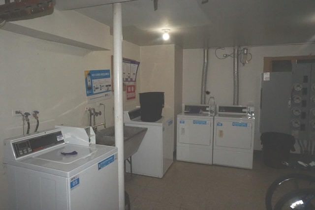 common laundry area with separate washer and dryer and a sink