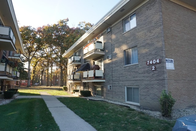 view of home's exterior with brick siding and a yard